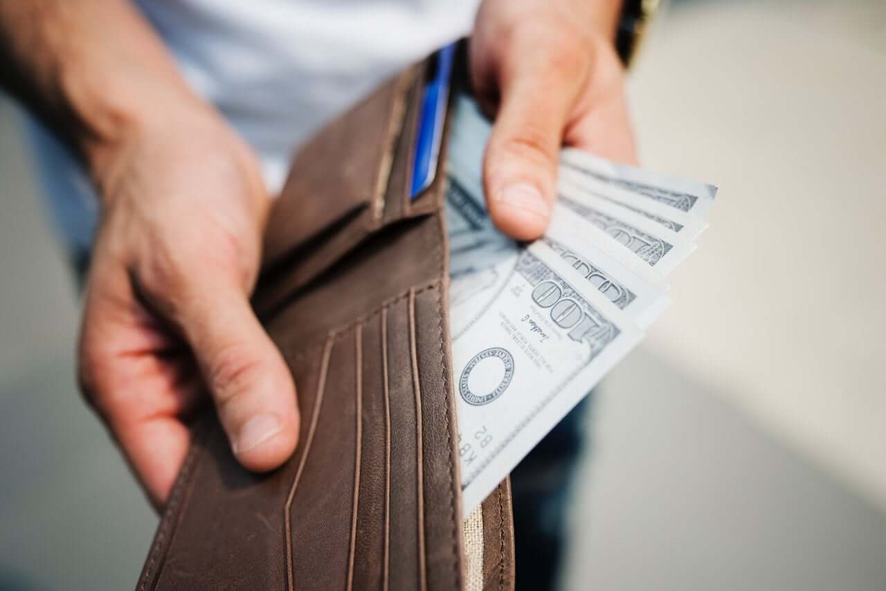 man taking money out of wallet