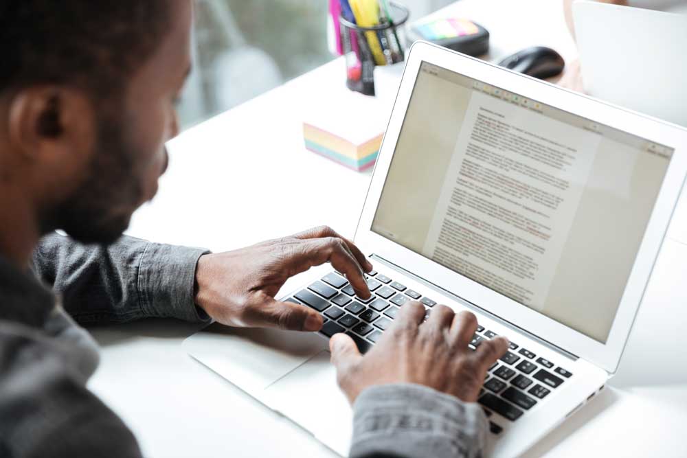 blog writing services add helpful content to websites image shows man typing on laptop